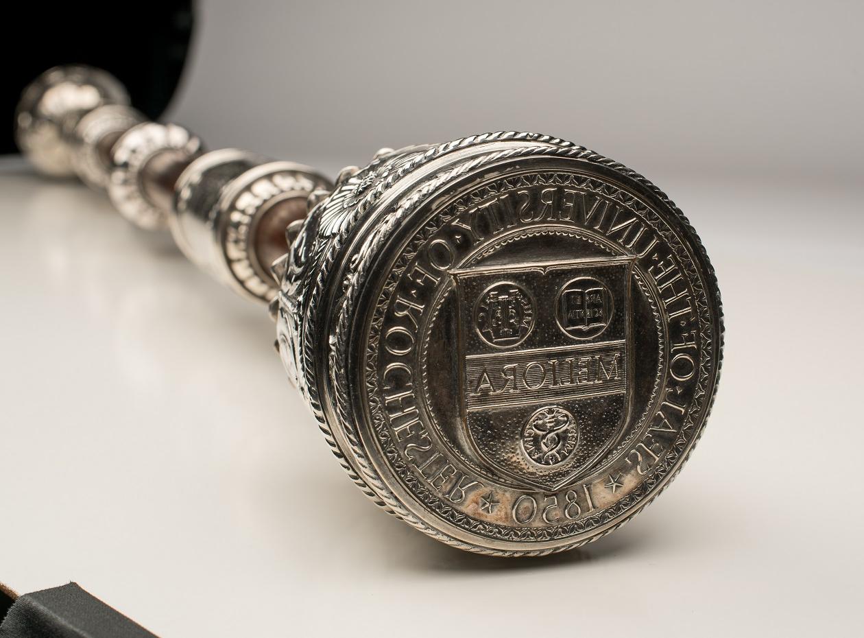 A University of Rochester mace and baton with the Meliora insignia